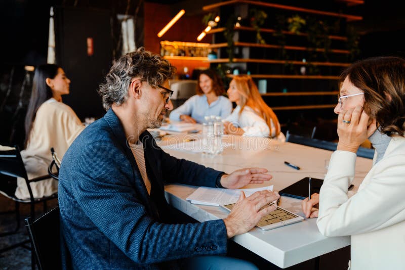 Ältere Kollegen diskutieren ihr Projekt während des Offline-Treffens lizenzfreies stockfoto