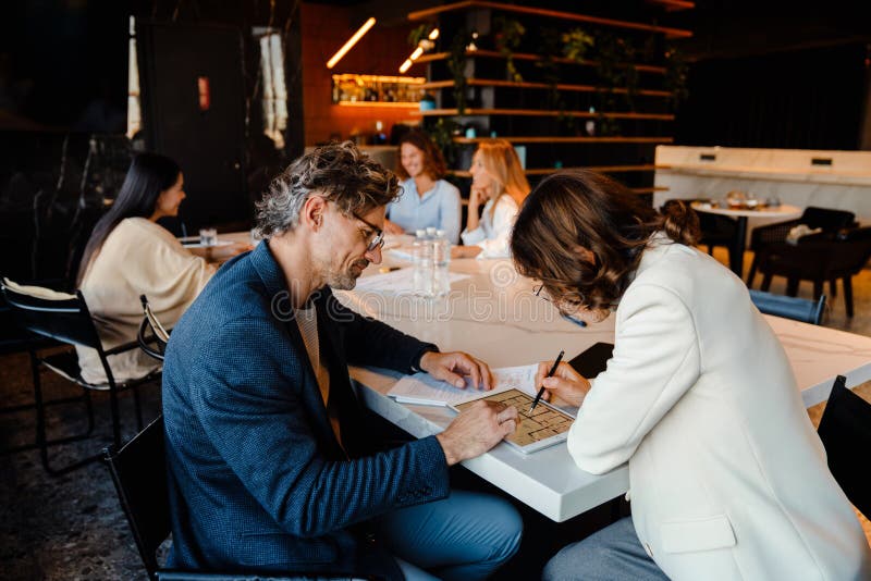 Ältere Kollegen diskutieren ihr Projekt während des Offline-Treffens lizenzfreie stockfotos