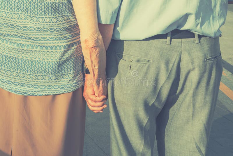 Ältere Leute-älteres Paar-Händchenhalten, das in die Straße geht Familienwert-romantische Liebes-Hingabe-Zusammengehörigkeit Fide