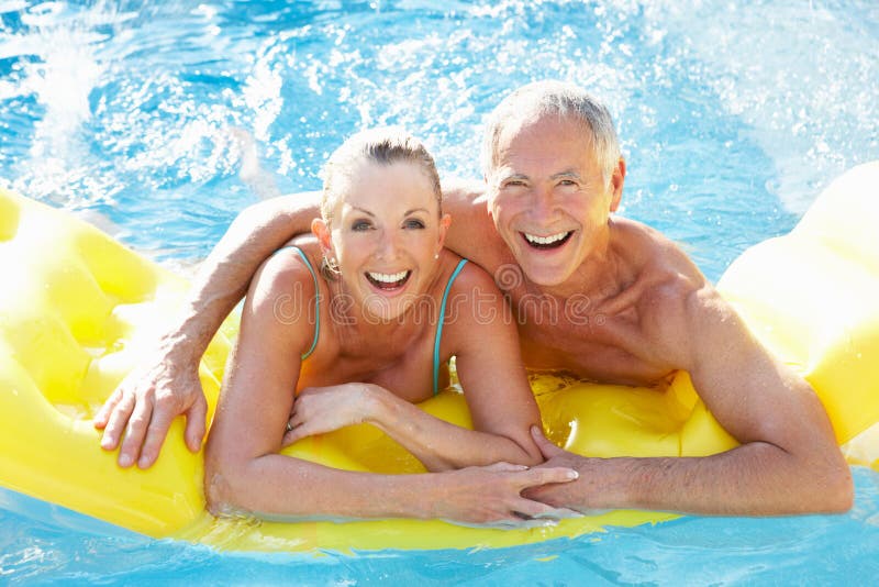 Ältere Paare, die Spaß im Pool haben