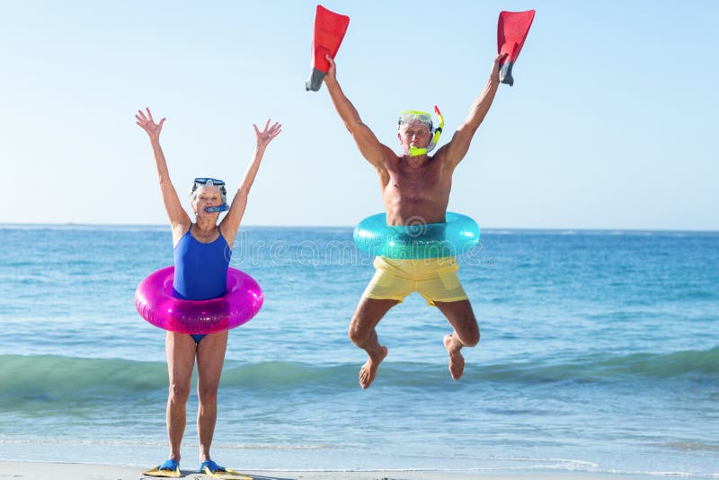 Ältere Paare mit Strandausrüstung lizenzfreies stockbild Ältere Paare mit Strandausrüstung lizenzfreies stockbild