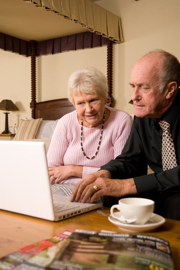 Ältere Paare unter Verwendung des Laptops