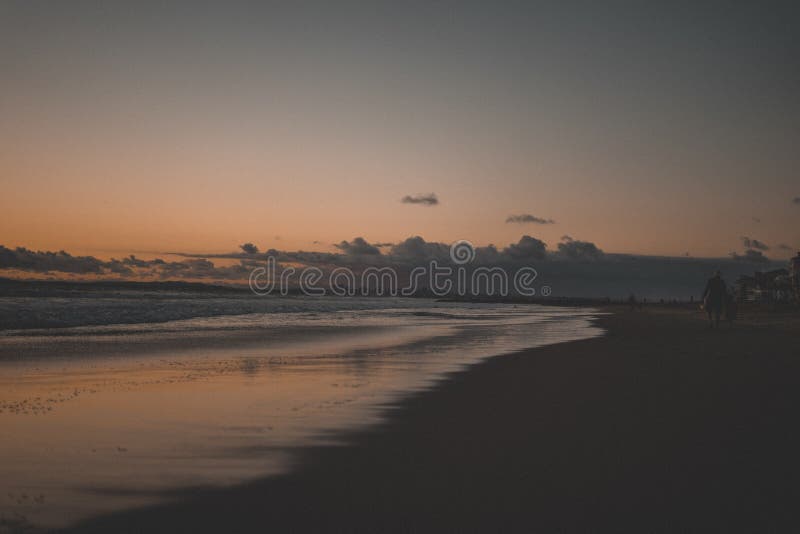 Ältere Person, die auf den schönen sandigen Strand bei Sonnenuntergang geht stockbilder Ältere Person, die auf den schönen sandigen Strand bei Sonnenuntergang geht stockbilder