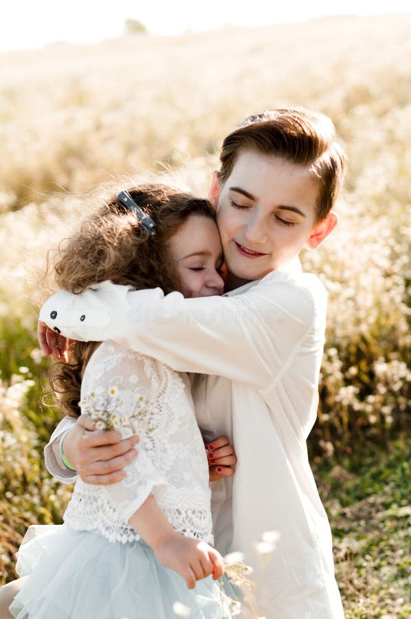 Älterer Bruder umarmt seine kleine Schwester stockbild Älterer Bruder umarmt seine kleine Schwester stockbild