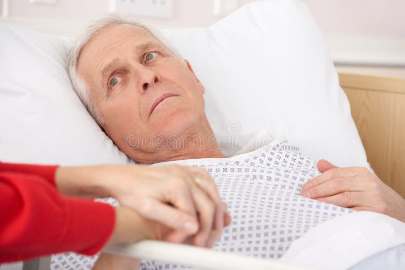 Älterer Mann in der Hand der Krankenhausbett-Holdingfrau