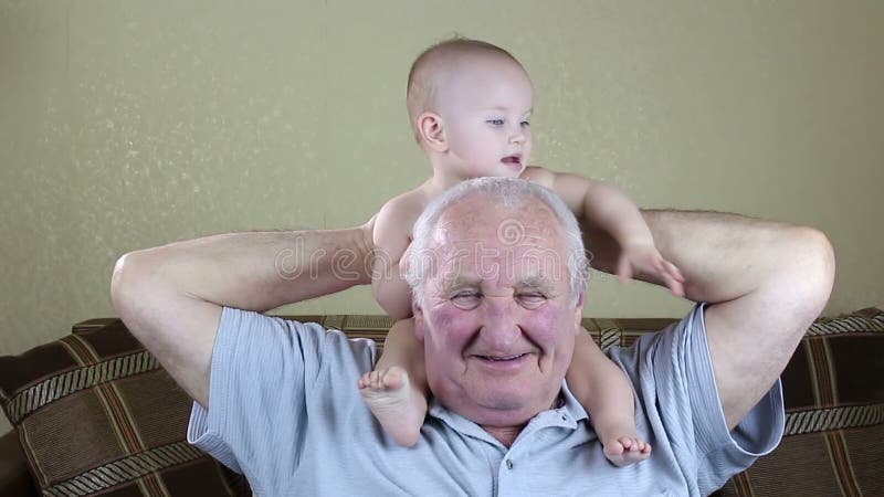 Älterer Mann, der mit einem Baby spielt