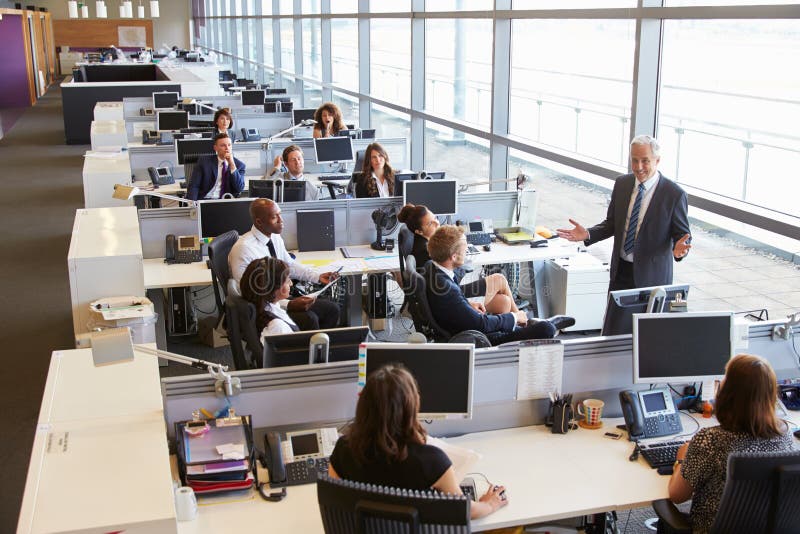 Älterer männlicher Manager, welche zu Arbeitskräften im Bürogroßraum spricht lizenzfreie stockfotos Älterer männlicher Manager, welche zu Arbeitskräften im Bürogroßraum spricht lizenzfreie stockfotos