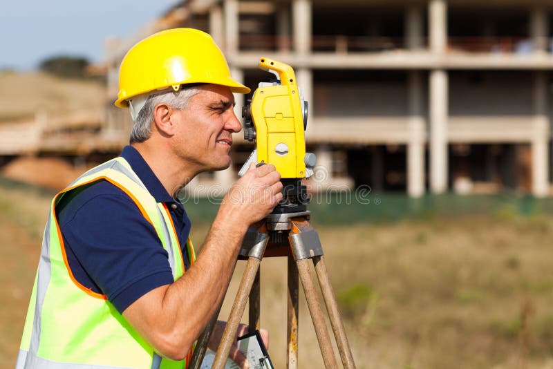 Senior land surveyor working with theodolite at construction site. Senior land surveyor working with theodolite at construction site