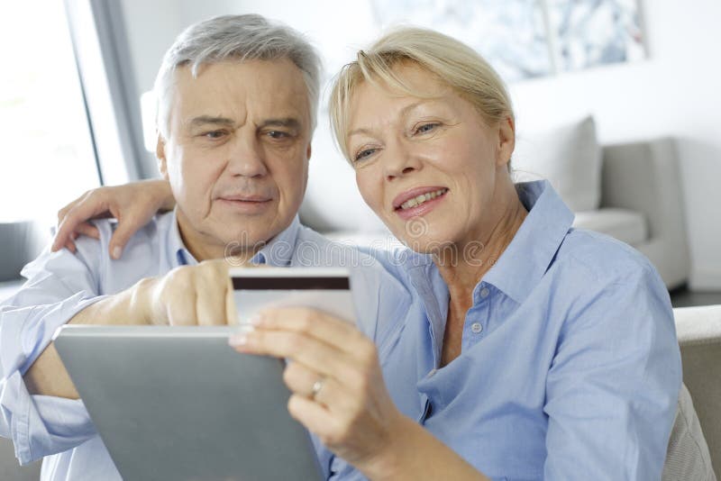 Älteres Paareinkaufen auf Internet lizenzfreies stockbild Älteres Paareinkaufen auf Internet lizenzfreies stockbild