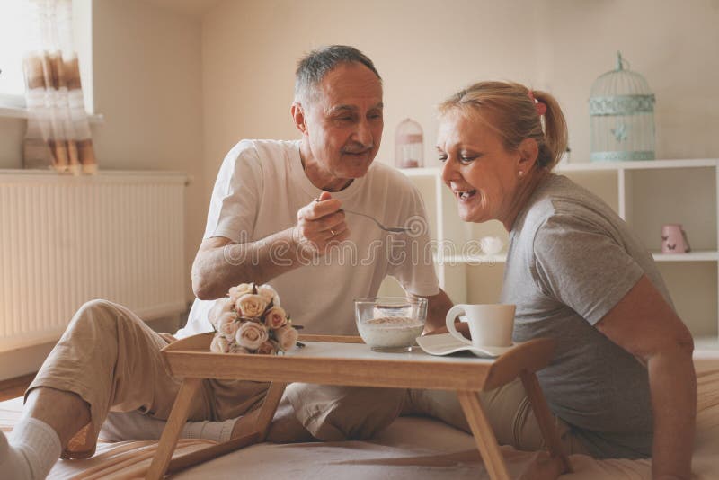 Älteres Paarfrühstück im Bett lizenzfreies stockfoto Älteres Paarfrühstück im Bett lizenzfreies stockfoto