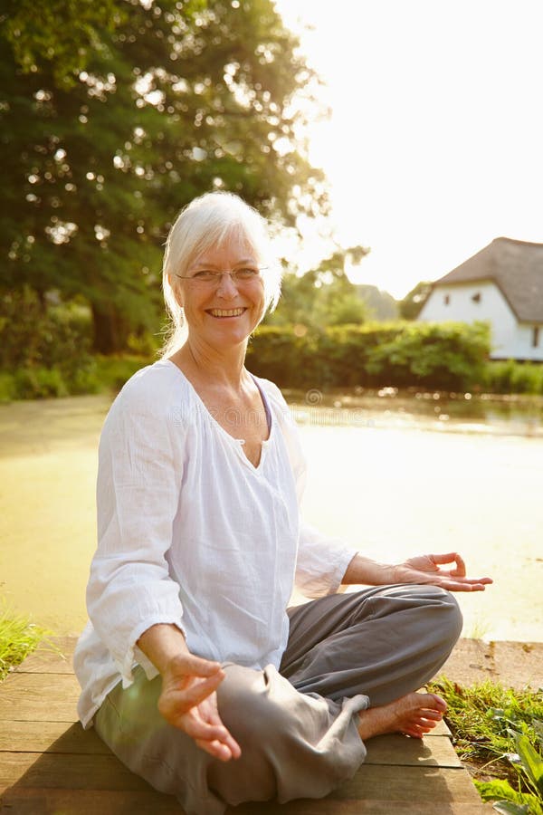 Changing my attitude towards life. Portrait of an attractive mature woman doing yoga in a beautiful garden setting. Changing my attitude towards life. Portrait of an attractive mature woman doing yoga in a beautiful garden setting