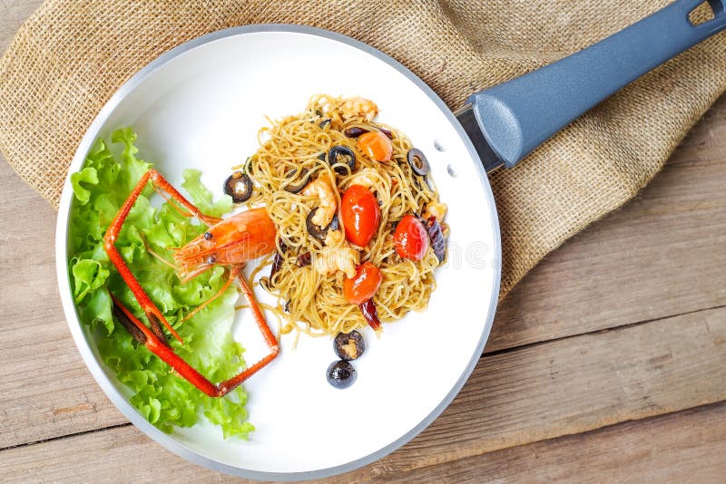 Ängelhårpasta med den jätte- räkan, oliv, tomater och chili royaltyfri bild Ängelhårpasta med den jätte- räkan, oliv, tomater och chili royaltyfri bild