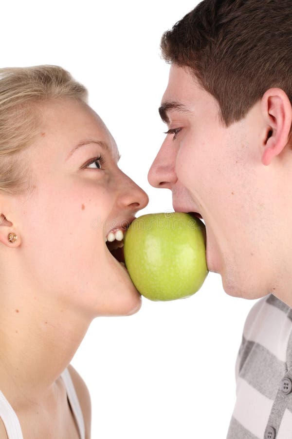 Girl and young man bite together green apple. Girl and young man bite together green apple