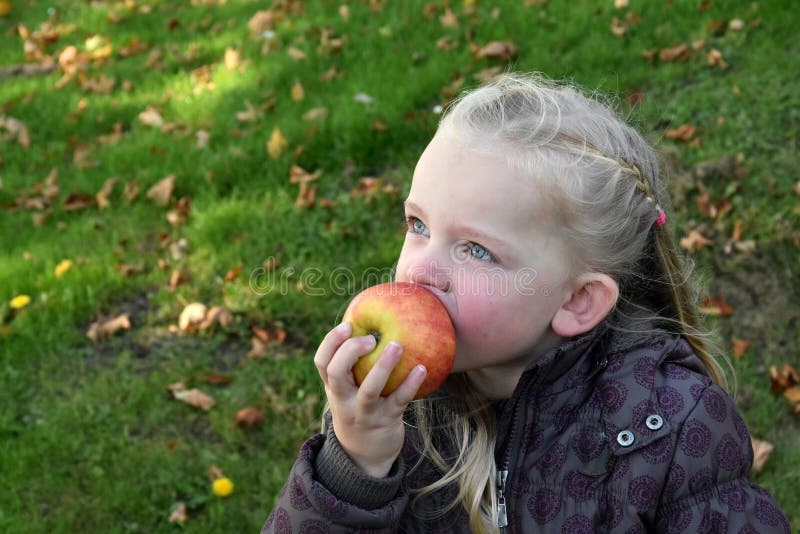 Beautiful little caucasian girl eating an apple. Beautiful little caucasian girl eating an apple
