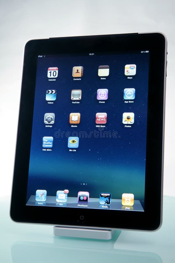 New Apple iPad displaying the main application screen. Docked and placed on a glossy surface. New Apple iPad displaying the main application screen. Docked and placed on a glossy surface.