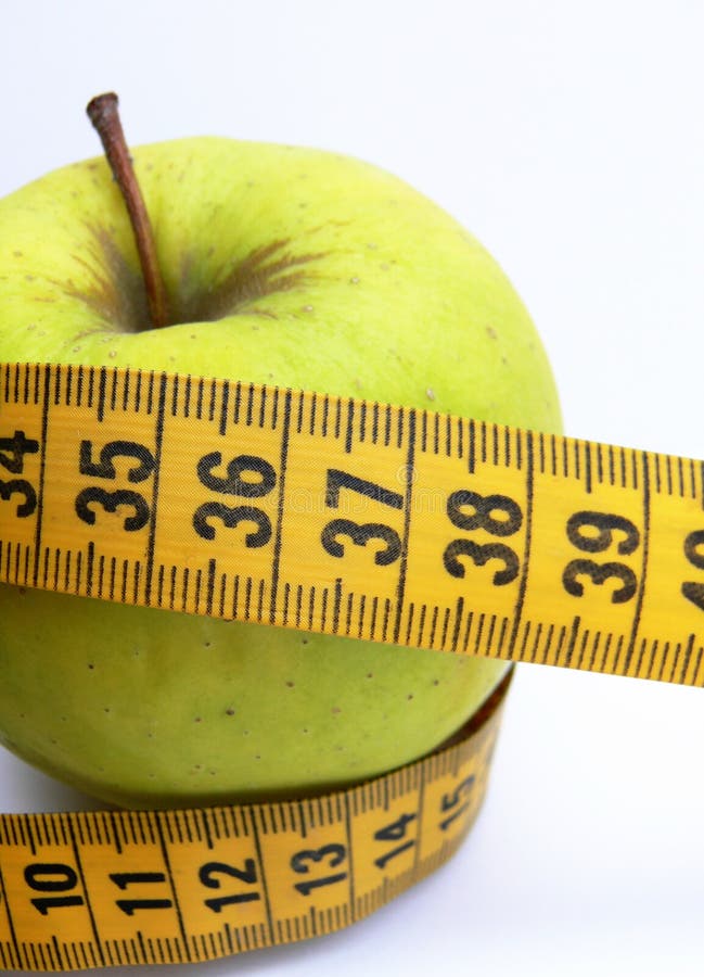 The apple with tape measure on the white background. The apple with tape measure on the white background.