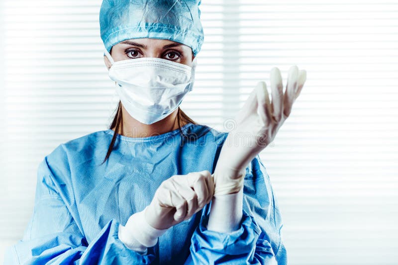 Ärztin Surgeon, das auf chirurgische Handschuhe sich setzt