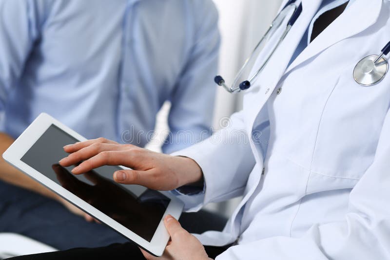 Ärztin unter Verwendung der Berührungsfläche oder des Tablet-Computers bei der Konsultierung des Mannpatienten im Krankenhaus Medizin- und Gesundheitswesenkonzept