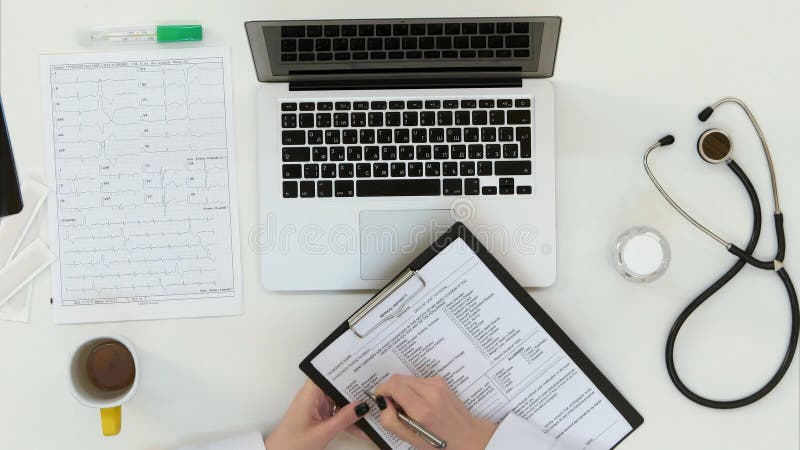 Ärztinhände, die Krankengeschichteform ausfüllen lizenzfreie stockfotos Ärztinhände, die Krankengeschichteform ausfüllen lizenzfreie stockfotos
