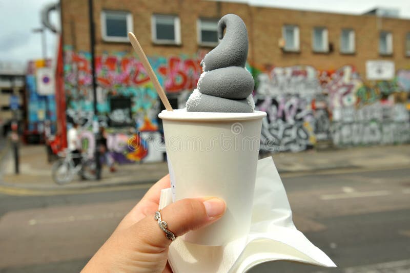 Äta svart glass med kol i Shoreditch, östliga London arkivbilder Äta svart glass med kol i Shoreditch, östliga London arkivbilder