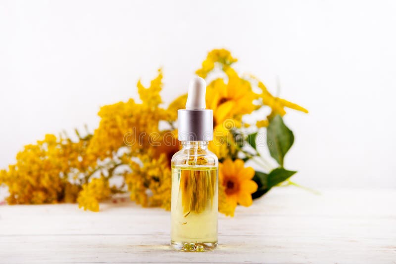 Ätherisches Öl, das von den Glastropfenzählerätherischen ölen und von den medizinischen Blumenkräutern fällt lizenzfreies stockbild Ätherisches Öl, das von den Glastropfenzählerätherischen ölen und von den medizinischen Blumenkräutern fällt lizenzfreies stockbild