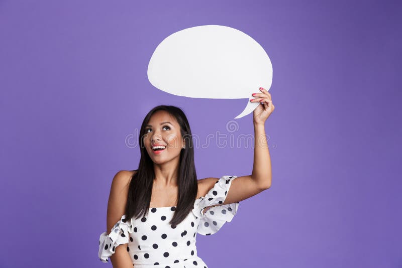 一名激动的亚裔妇女的画象拿着空白的讲话泡影的礼服的 库存照片 一名激动的亚裔妇女的画象拿着空白的讲话泡影的礼服的 库存照片