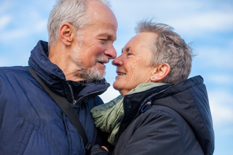 Åldringpar som omfamnar och firar solen royaltyfri foto Åldringpar som omfamnar och firar solen royaltyfri foto