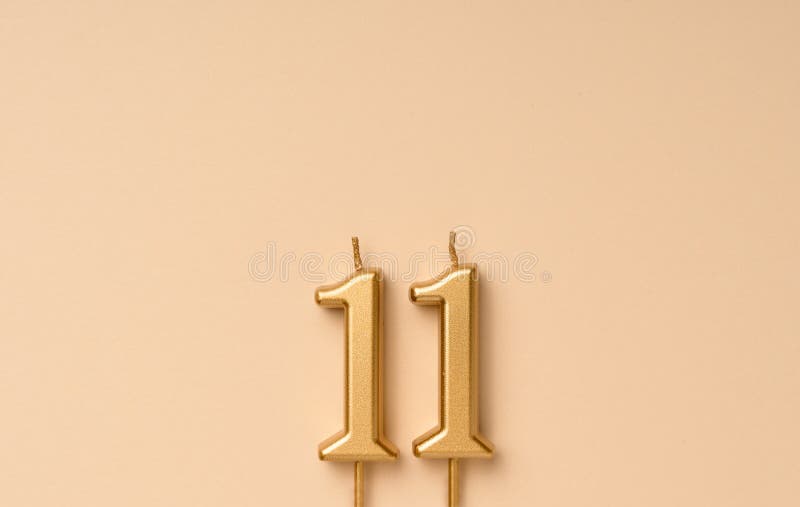 11 years celebration festive background made with golden candles in the form of number eleven. Universal holiday banner with copy space. 11 years celebration festive background made with golden candles in the form of number eleven. Universal holiday banner with copy space