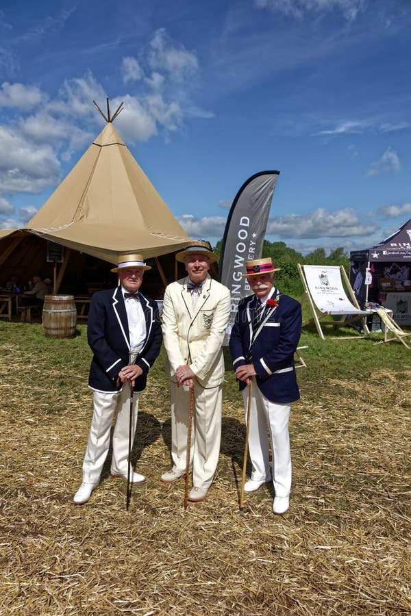 Stockton, Wiltshire / UK - June 2 2018:  Three dapperly dressed men in straw boater hats with bow ties and walking canes at the 2018 Stockton village Vintage Nostalgia Festival in Wiltshire. Stockton, Wiltshire / UK - June 2 2018:  Three dapperly dressed men in straw boater hats with bow ties and walking canes at the 2018 Stockton village Vintage Nostalgia Festival in Wiltshire