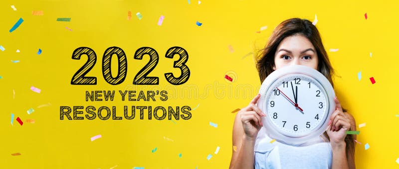 2023 års nya resolutioner med unga kvinnor som håller klockan royaltyfria bilder