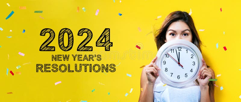 2024 års nya resolutioner med unga kvinnor som håller klockan royaltyfria foton