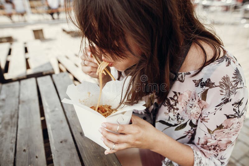 吃与菜和海鲜的时髦的行家女孩铁锅面条从有竹筷子的纸盒箱子 亚洲食物街道 库存照片 吃与菜和海鲜的时髦的行家女孩铁锅面条从有竹筷子的纸盒箱子 亚洲食物街道 库存照片