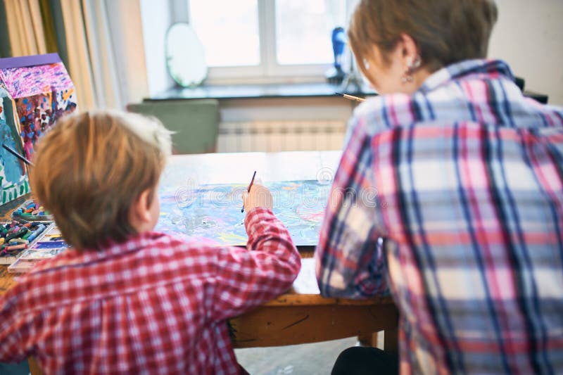 Śliczny szczęśliwy chłopiec i nauczyciela rysunek w artysta klasie jest edukacja starego odizolowane pojęcia Pepiniery i Preschoo obrazy royalty free