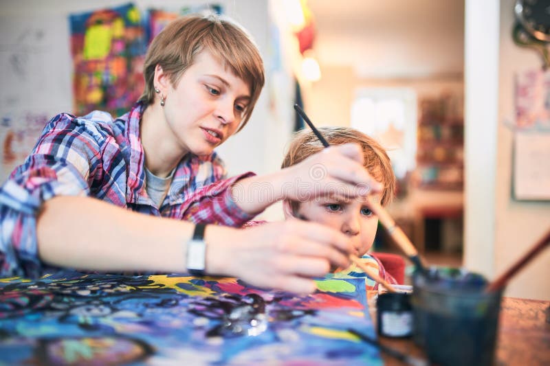 Śliczny szczęśliwy chłopiec i nauczyciela rysunek w artysta klasie jest edukacja starego odizolowane pojęcia Pepiniery i Preschoo fotografia stock