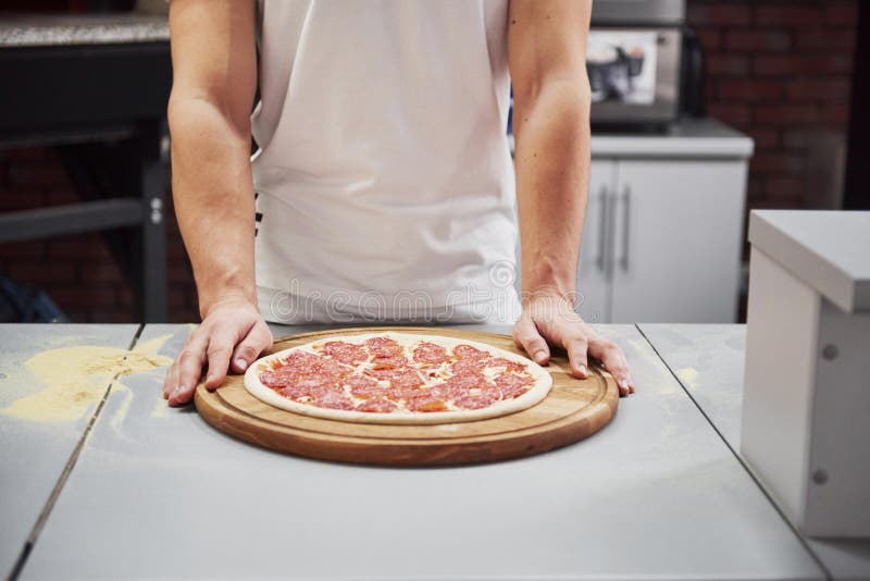 Ça va être délicieux Vue rapprochée du boulanger avec des pizzas prêtes à être mises au four pour cuisiner