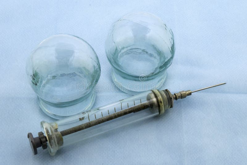 玻璃按摩医疗罐和一个老玻璃注射器 库存照片 玻璃按摩医疗罐和一个老玻璃注射器 库存照片