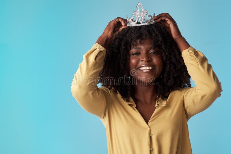 è un mondo regno e ci vivevano tutti. studio di una giovane donna che mette la corona contro una corona blu fotografia stock libera da diritti