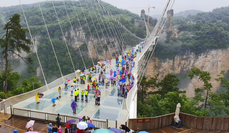 30th of May: Tourists walking and taking pictures in a rainy day at the Glass Bridge Grand Canyon, Wulingyuan, Zhangjiajie National Forest Park, Hunan Province, China, Asia. 30th of May: Tourists walking and taking pictures in a rainy day at the Glass Bridge Grand Canyon, Wulingyuan, Zhangjiajie National Forest Park, Hunan Province, China, Asia.