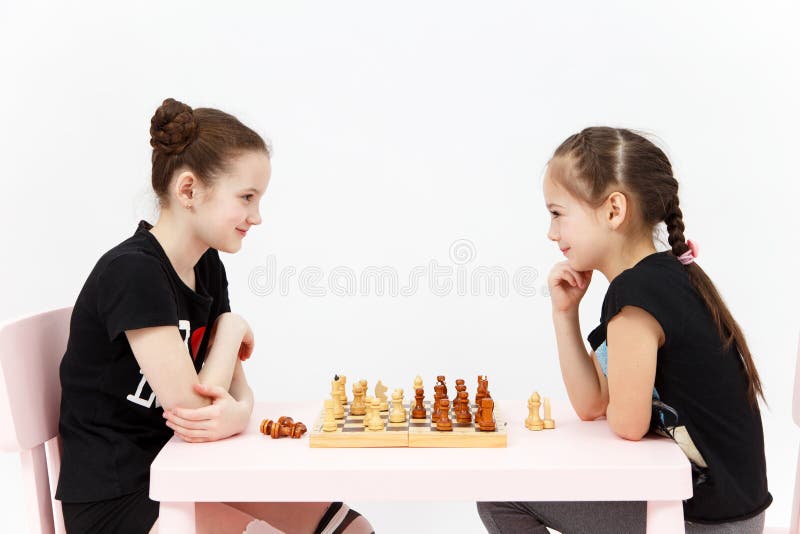 Échecs de jeu de deux filles sur le fond blanc image libre de droits Échecs de jeu de deux filles sur le fond blanc image libre de droits