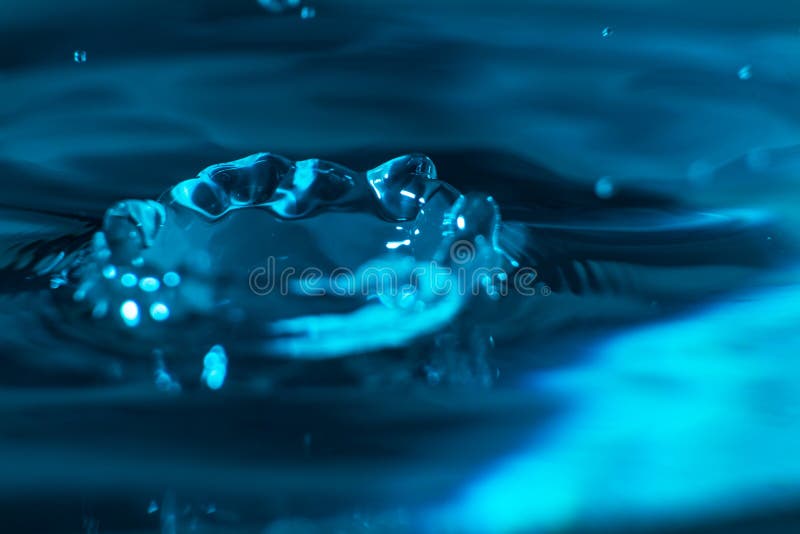 Éclaboussure d'une goutte de l'eau en tombant sur l'eau clair comme de l'eau de roche Concept de nettoyage et de pureté Macro de photographie stock Éclaboussure d'une goutte de l'eau en tombant sur l'eau clair comme de l'eau de roche Concept de nettoyage et de pureté Macro de photographie stock