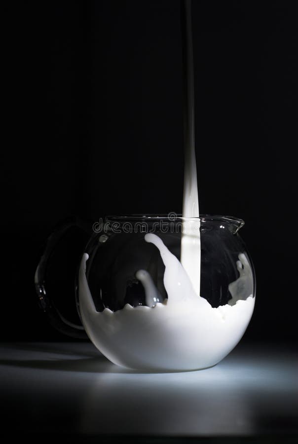 Éclaboussure de lait sur le noir photo stock Éclaboussure de lait sur le noir photo stock