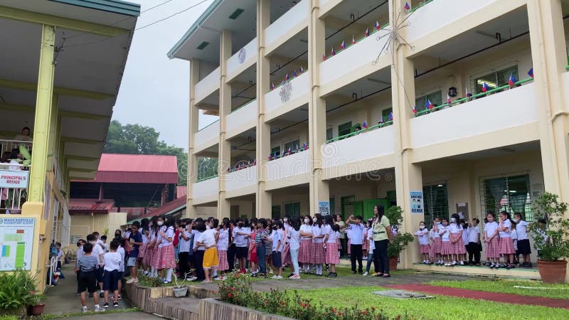 école primaire les enfants asiatiques se rassemblent sur le terrain de l'école pour participer au programme du petit matin
