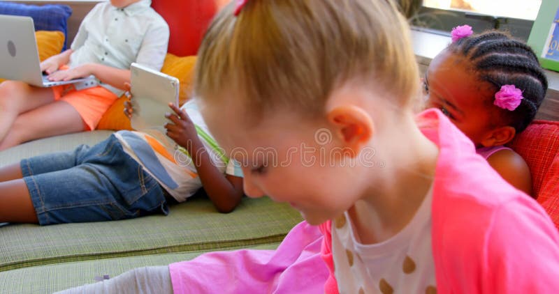 Écoliers ayant l'amusement dans la bibliothèque d'école 4k banque de vidéos