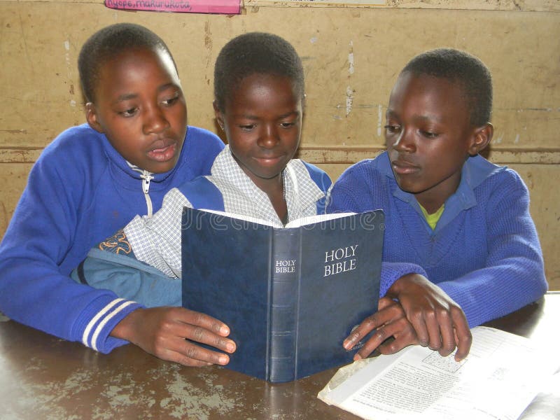 Écoliers primaires lisant la bible dans la salle de classe photos libres de droits