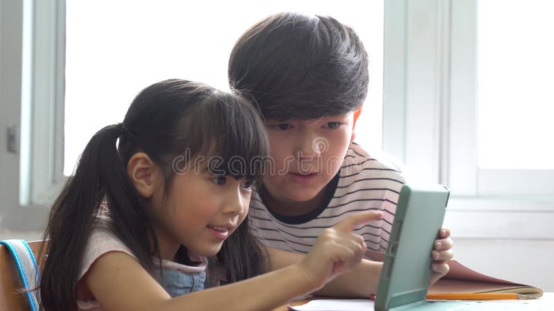 Écoliers utilisant le dispositif numérique de comprimé en technologie autochtone numérique de salle de classe d'école apprenant l' banque de vidéos