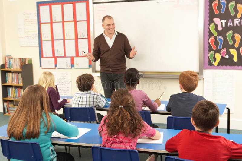 Écoliers étudiant dans la salle de classe avec le professeur photo libre de droits Écoliers étudiant dans la salle de classe avec le professeur photo libre de droits