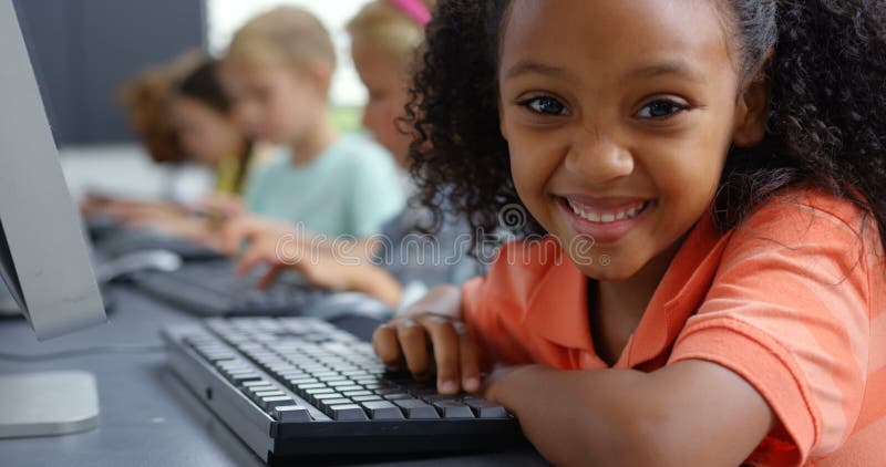 Écolière d'Afro-américain de vue de côté à l'aide du PC de bureau au bureau dans la salle de classe 4k clips vidéos