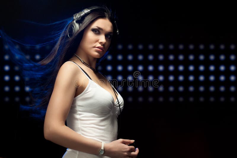 Écouteurs s'usants du DJ de beau femme photographie stock libre de droits Écouteurs s'usants du DJ de beau femme photographie stock libre de droits