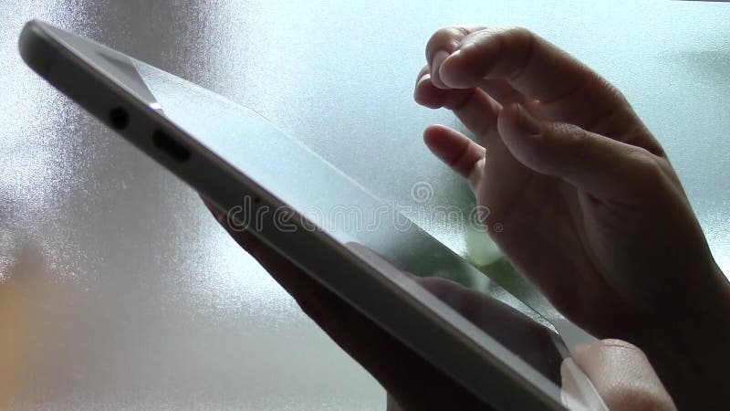 Mão de mulher a tocar no ecrã tátil de um tablet filme