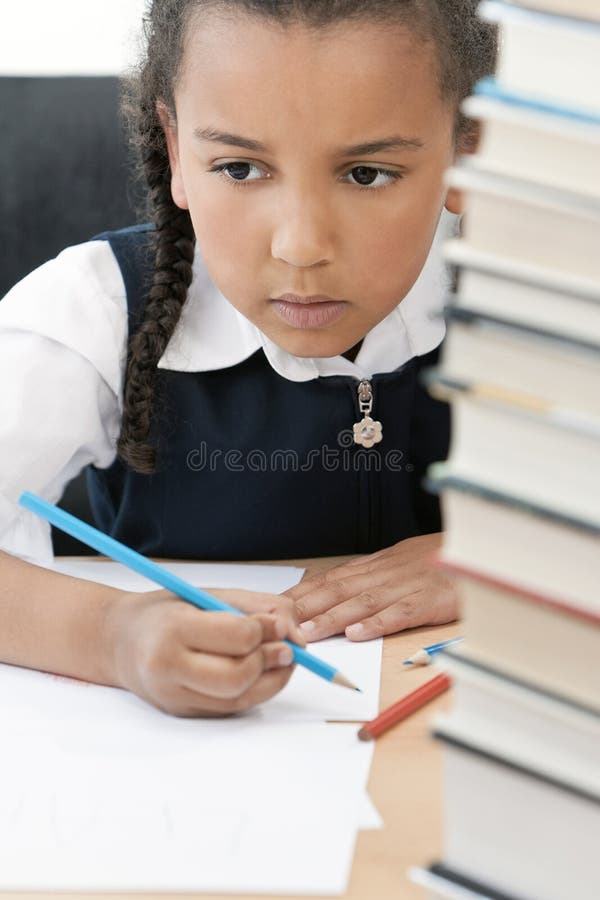 Écriture de fille d'école d'Afro-américain dans la classe image stock Écriture de fille d'école d'Afro-américain dans la classe image stock